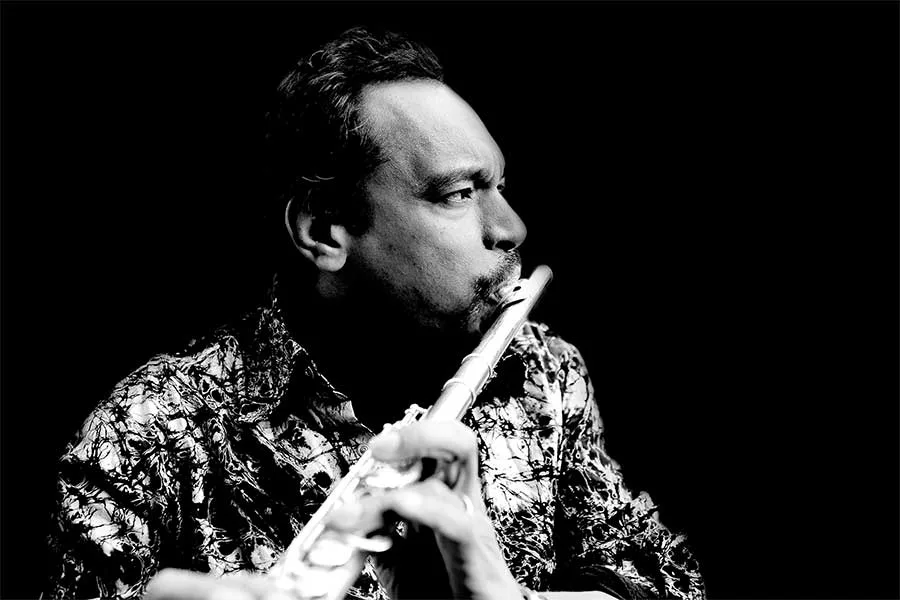 Black-and-white photo of Jay Rodriguez Sierra playing a wooden flute.