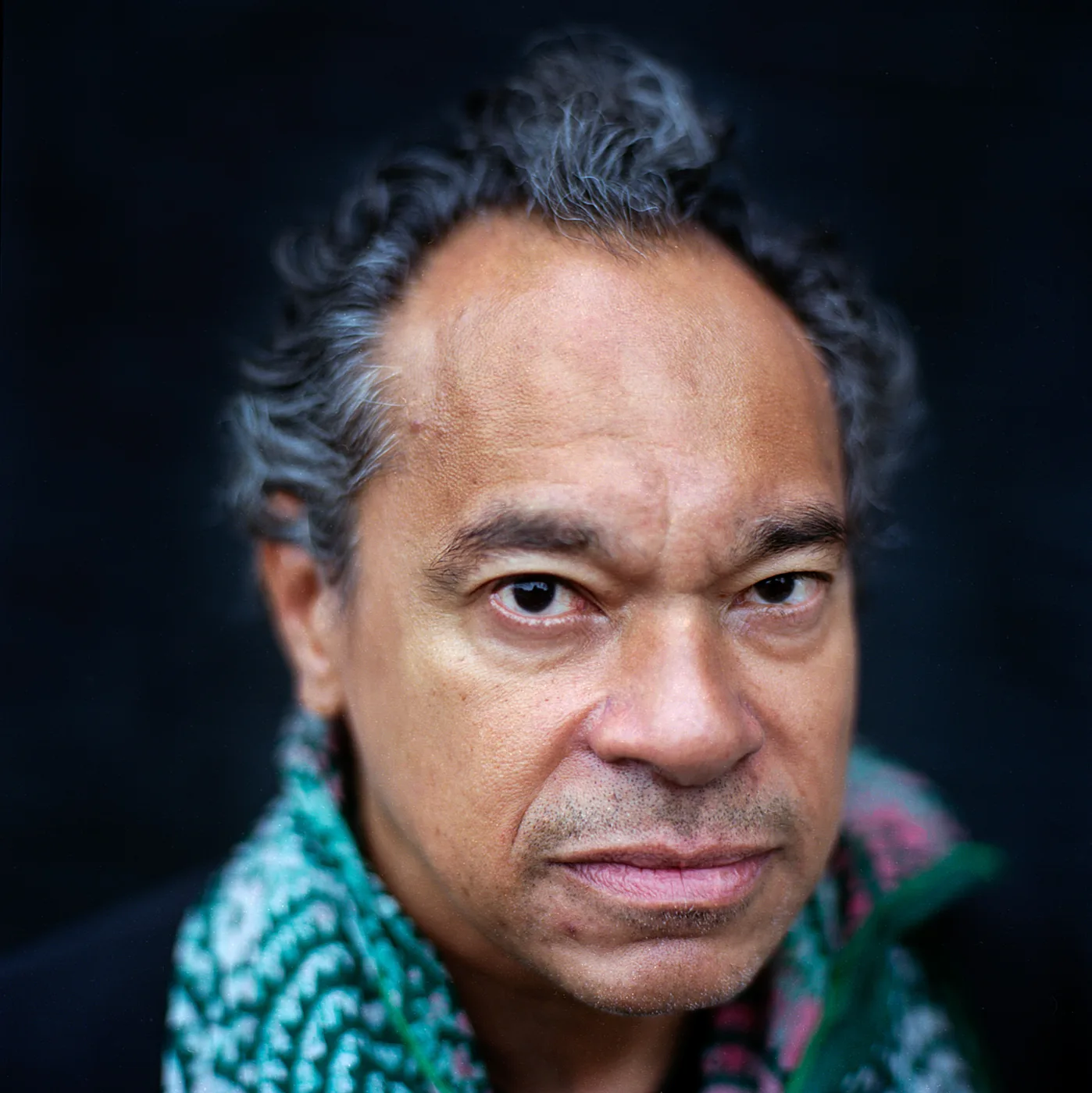 Portrait of Jay Rodriguez Sierra in a patterned scarf.
