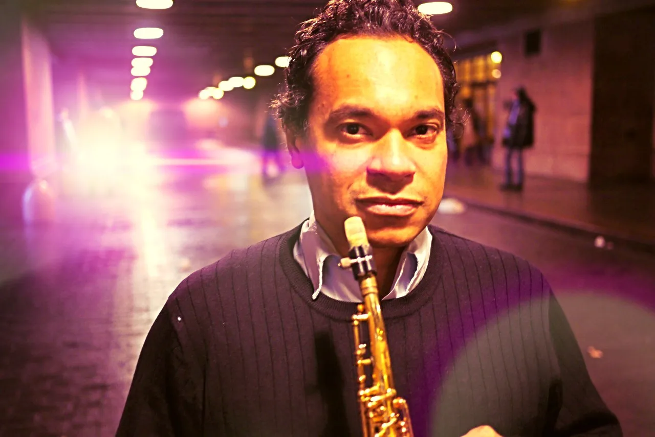Jay Rodriguez Sierra with soprano saxophone in a lit tunnel.